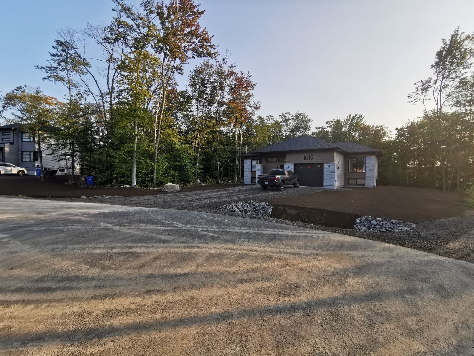 Une voiture est garée dans une allée devant une maison.