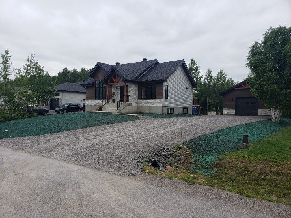 Une grande maison avec une allée de gravier devant elle.