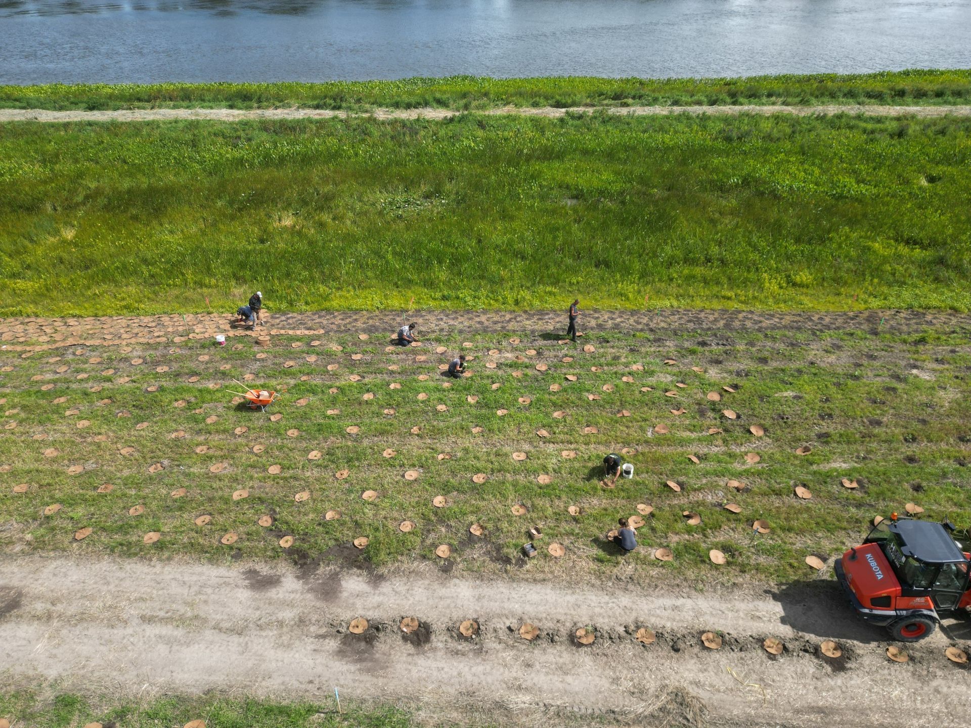 Une vue aérienne d'un champ avec une rivière en arrière-plan.
