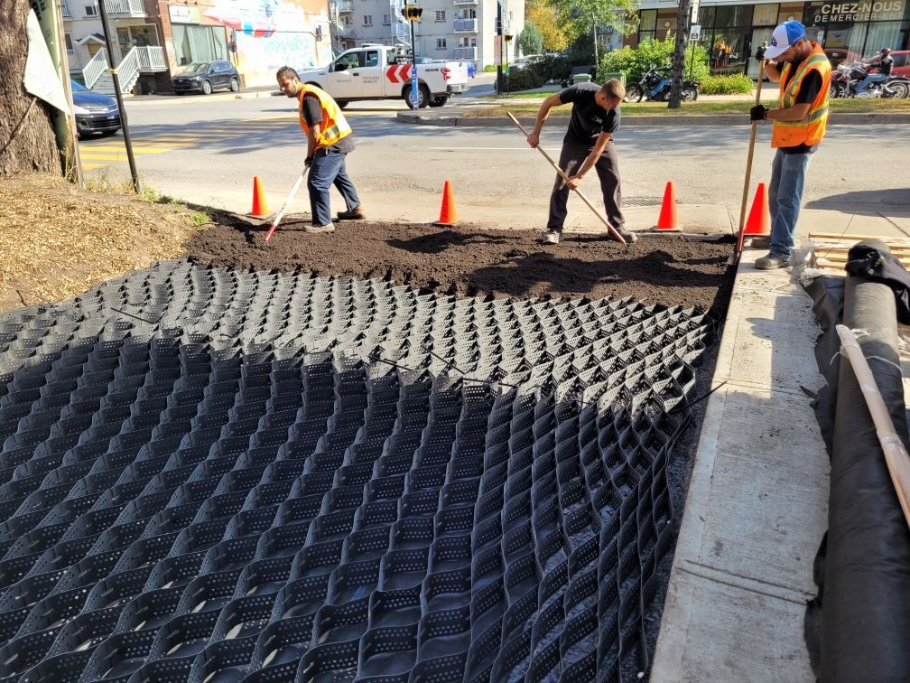 Un groupe d'ouvriers du bâtiment travaille sur un trottoir.