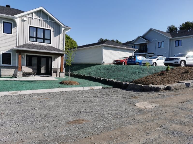 Une maison avec beaucoup de voitures garées devant.