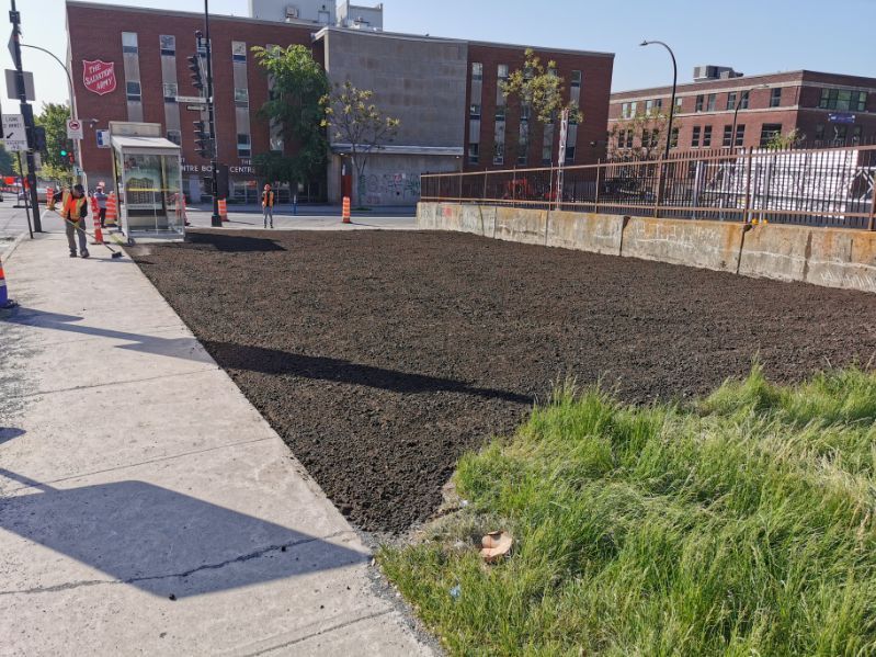 Il y a beaucoup de saleté sur le trottoir devant un bâtiment