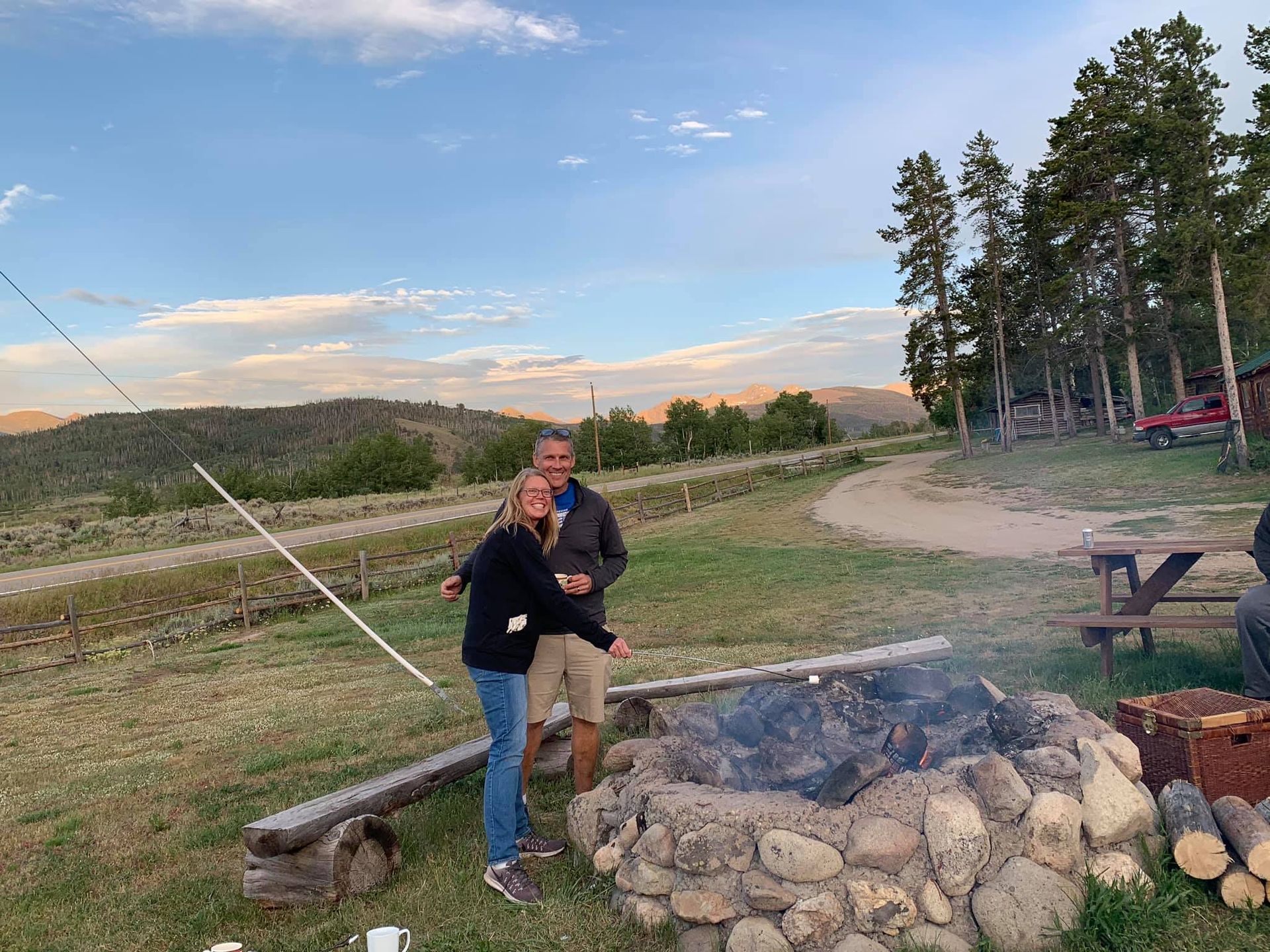 A man and a woman are standing next to a fire pit.