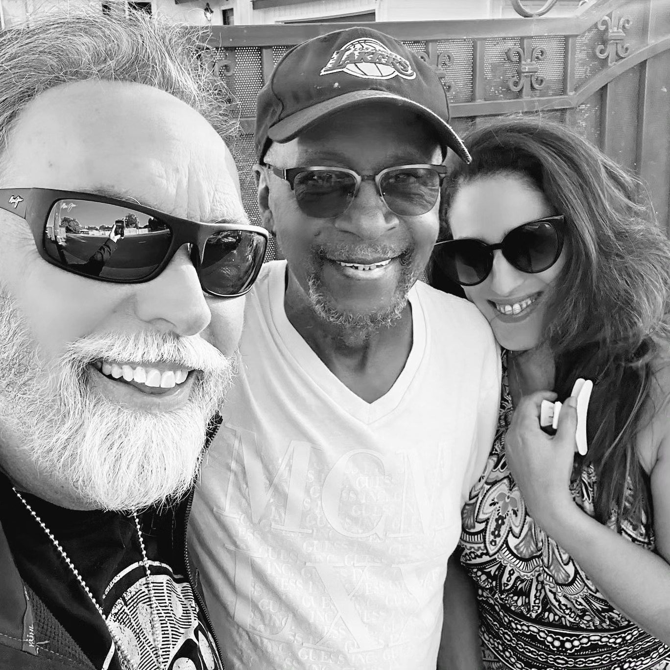 a black and white photo of three people wearing sunglasses