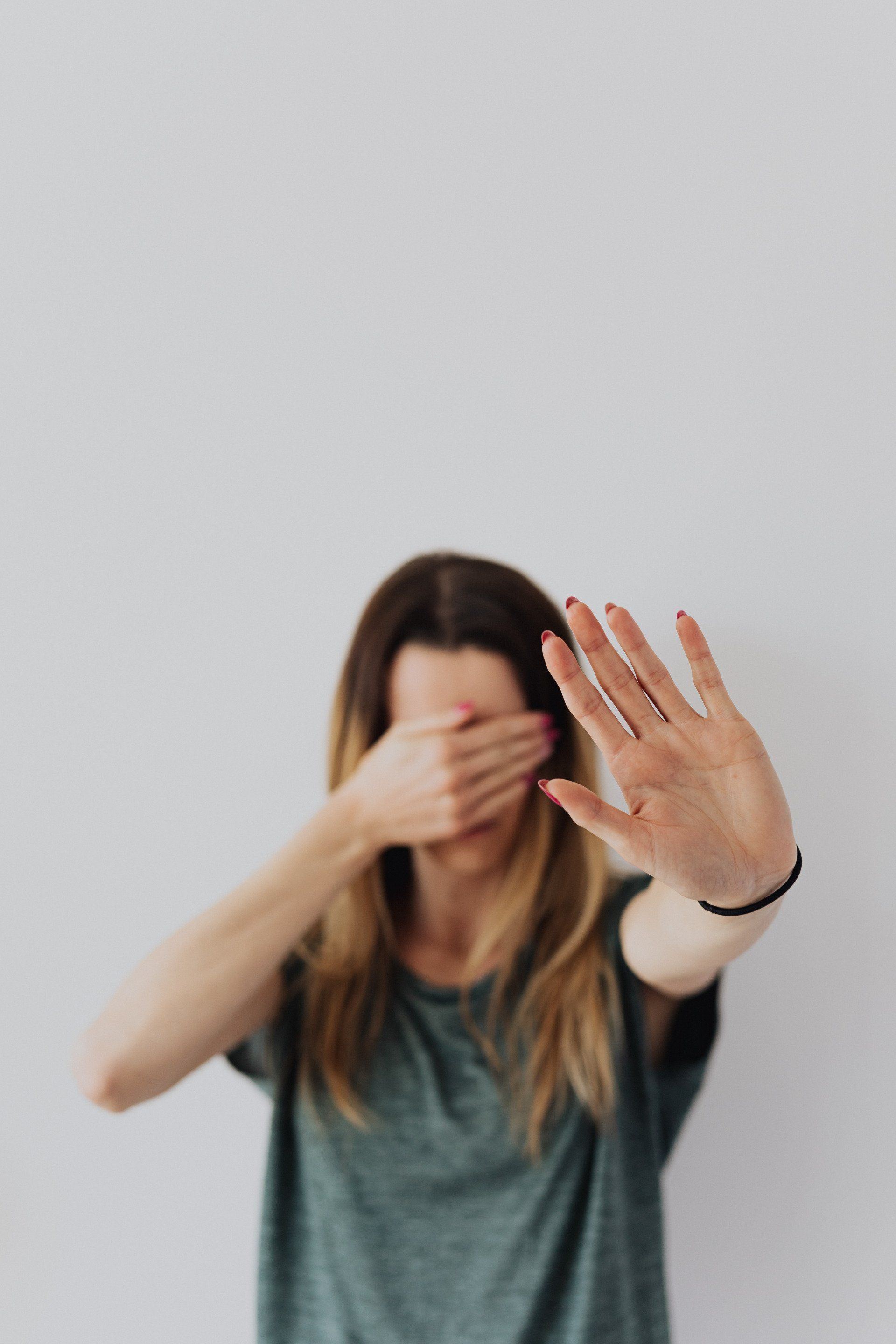 A woman is covering her face with her hand.