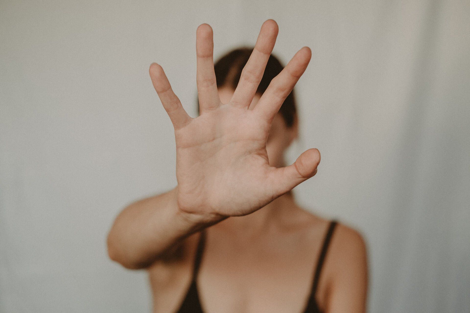 A woman is covering her face with her hand.