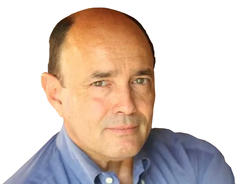 A bald man wearing a blue shirt looks at the camera