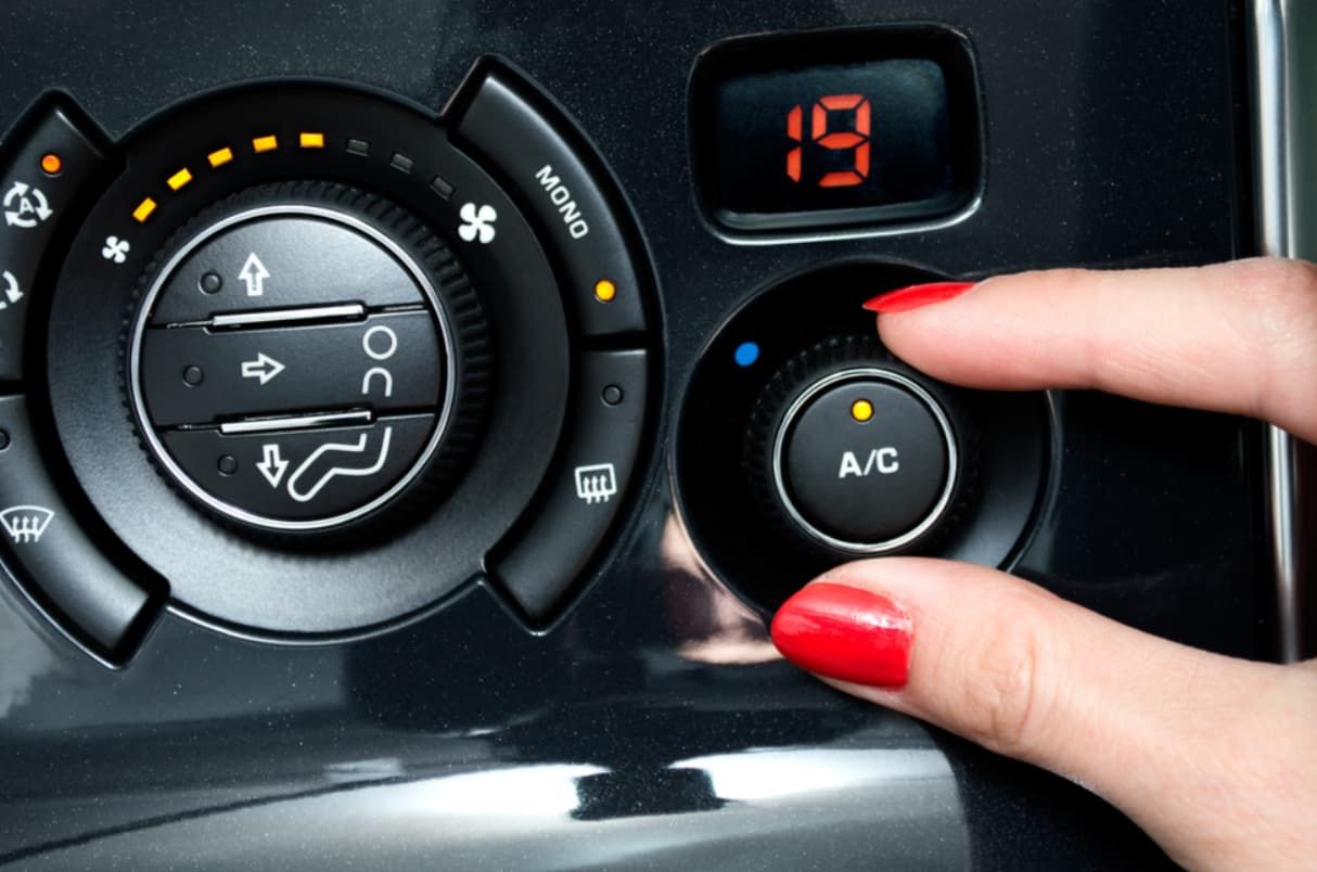 A Woman With Red Nails Is Adjusting The A/c In A Car — Bartons Auto Air Conditioning In Tolga, QLD