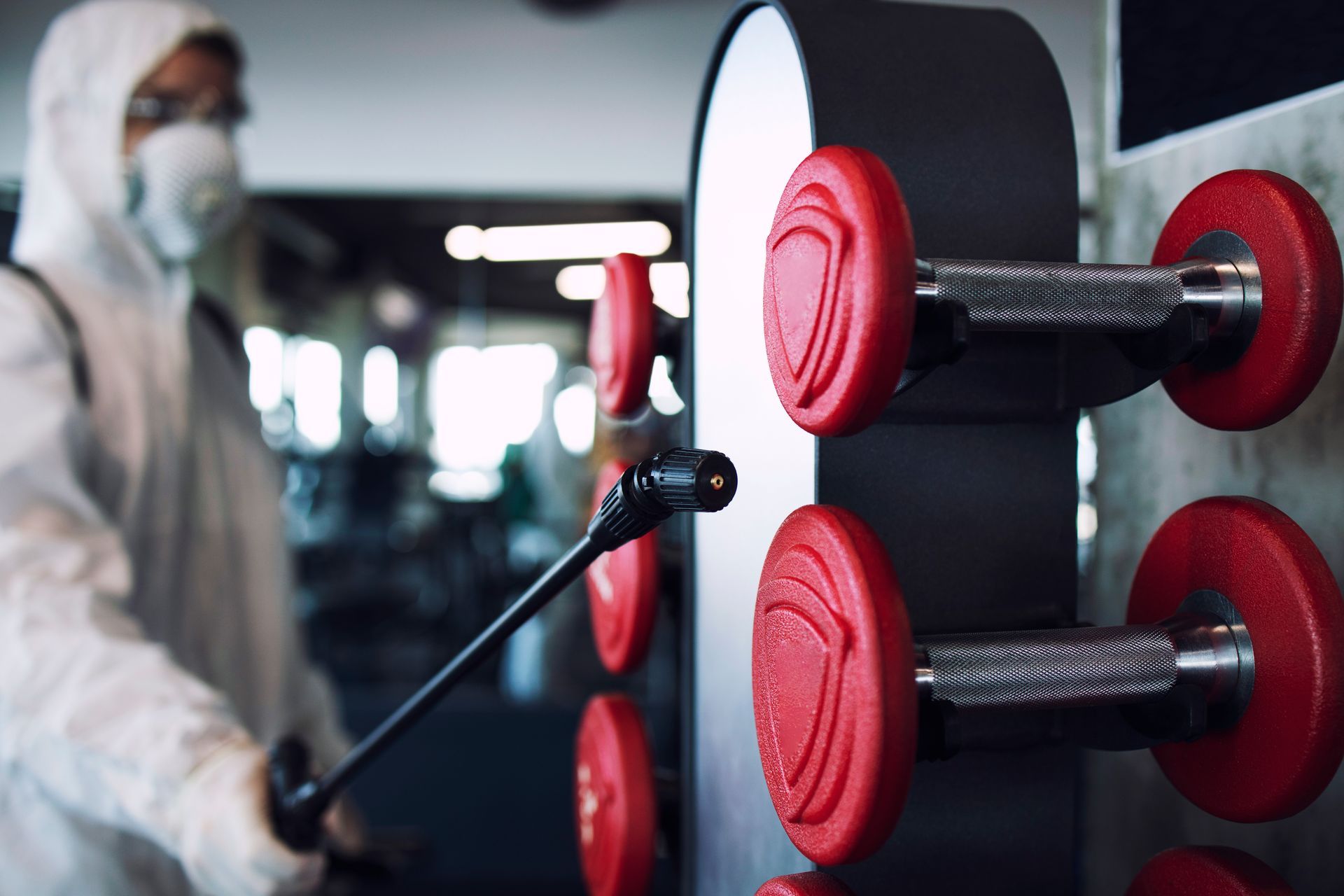 man disinfects weights at a fitness center