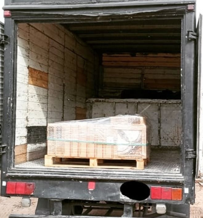 Zona de carga abierta de un camión con un palé de madera que contiene un artículo rectangular envuelto