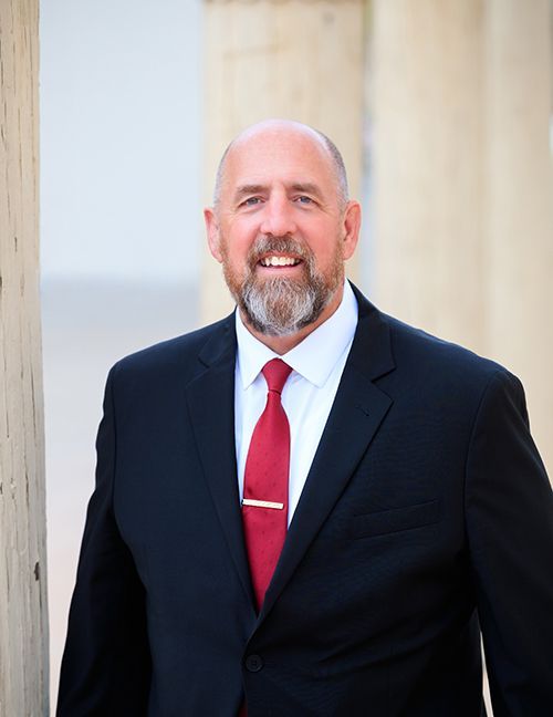 A man in a suit and tie is smiling for the camera. Pat Burns