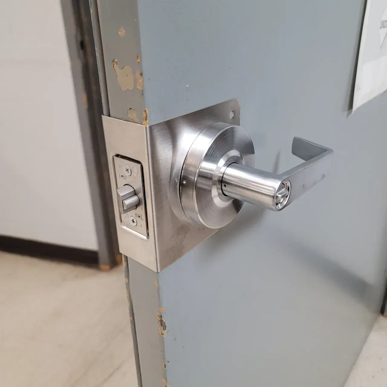 Locks Keys and More | A close up of a stainless steel door handle on a door.