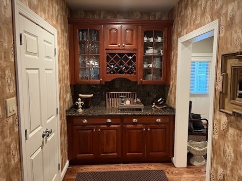 A kitchen with wooden cabinets and a wine rack.