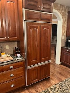 A kitchen with wooden cabinets and a stainless steel refrigerator freezer.