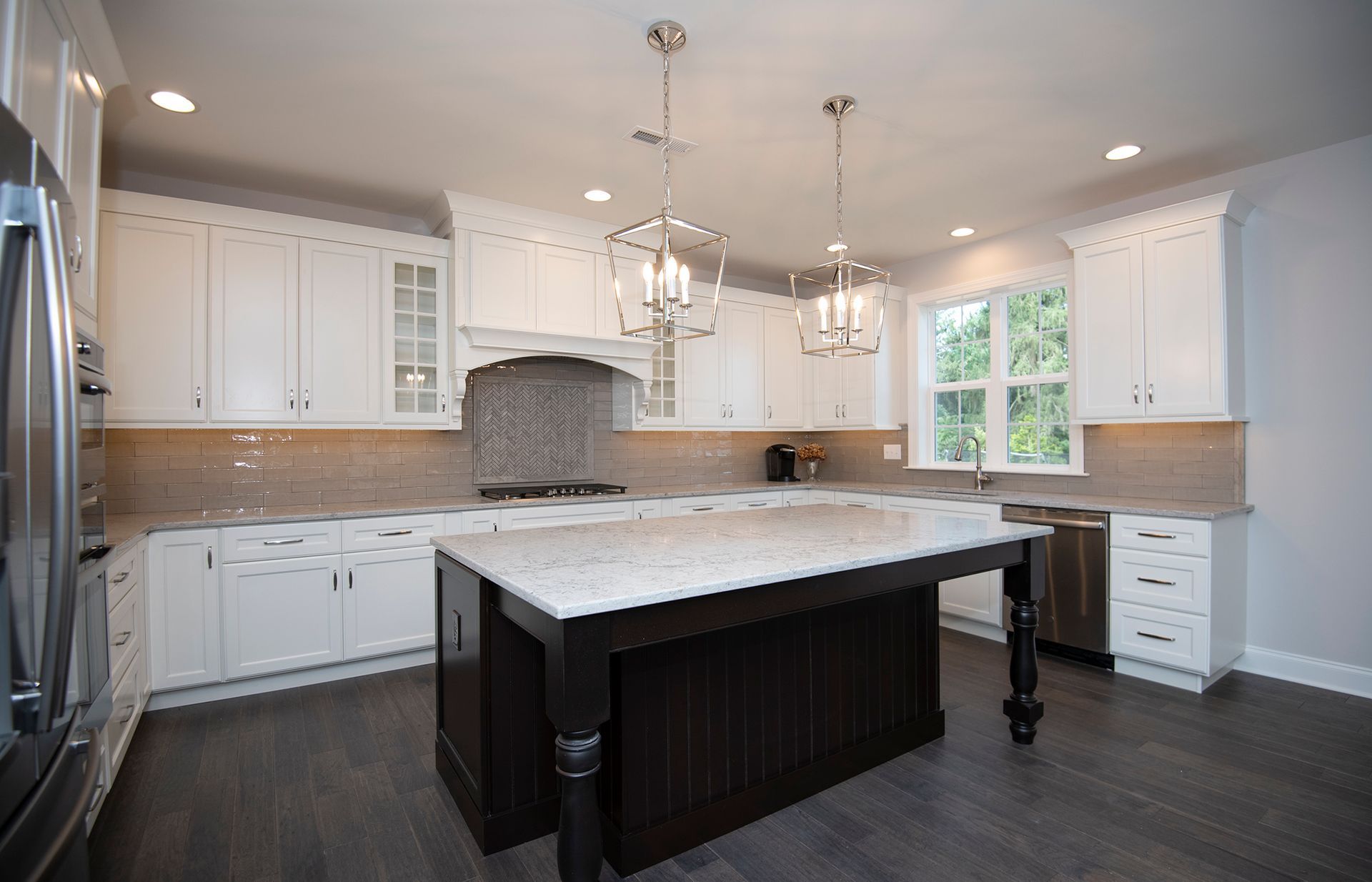 A kitchen with white cabinets and a large island in the middle