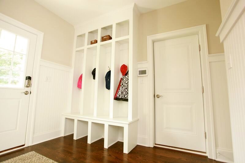 A hallway with a coat rack and a door