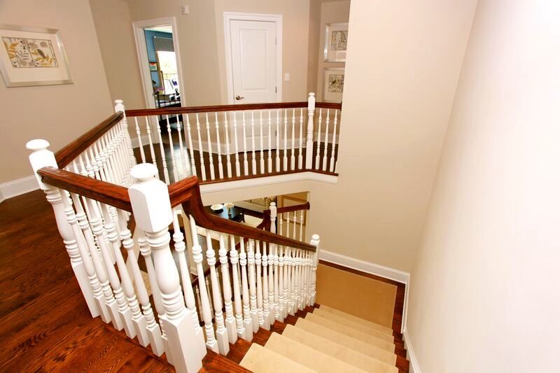 A staircase with a wooden railing and a white railing in a house.