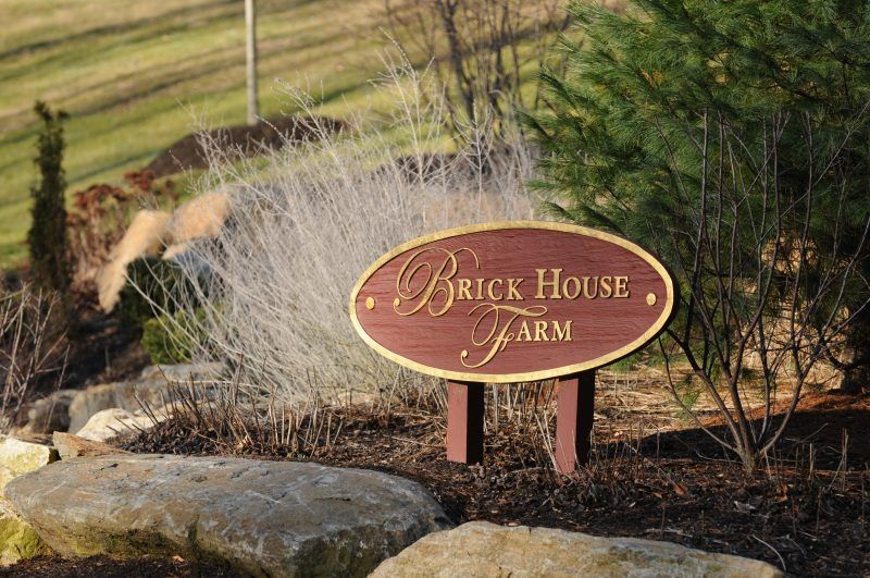 A sign that says brick house farm on it