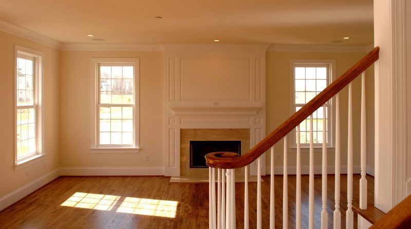 An empty living room with a fireplace and stairs