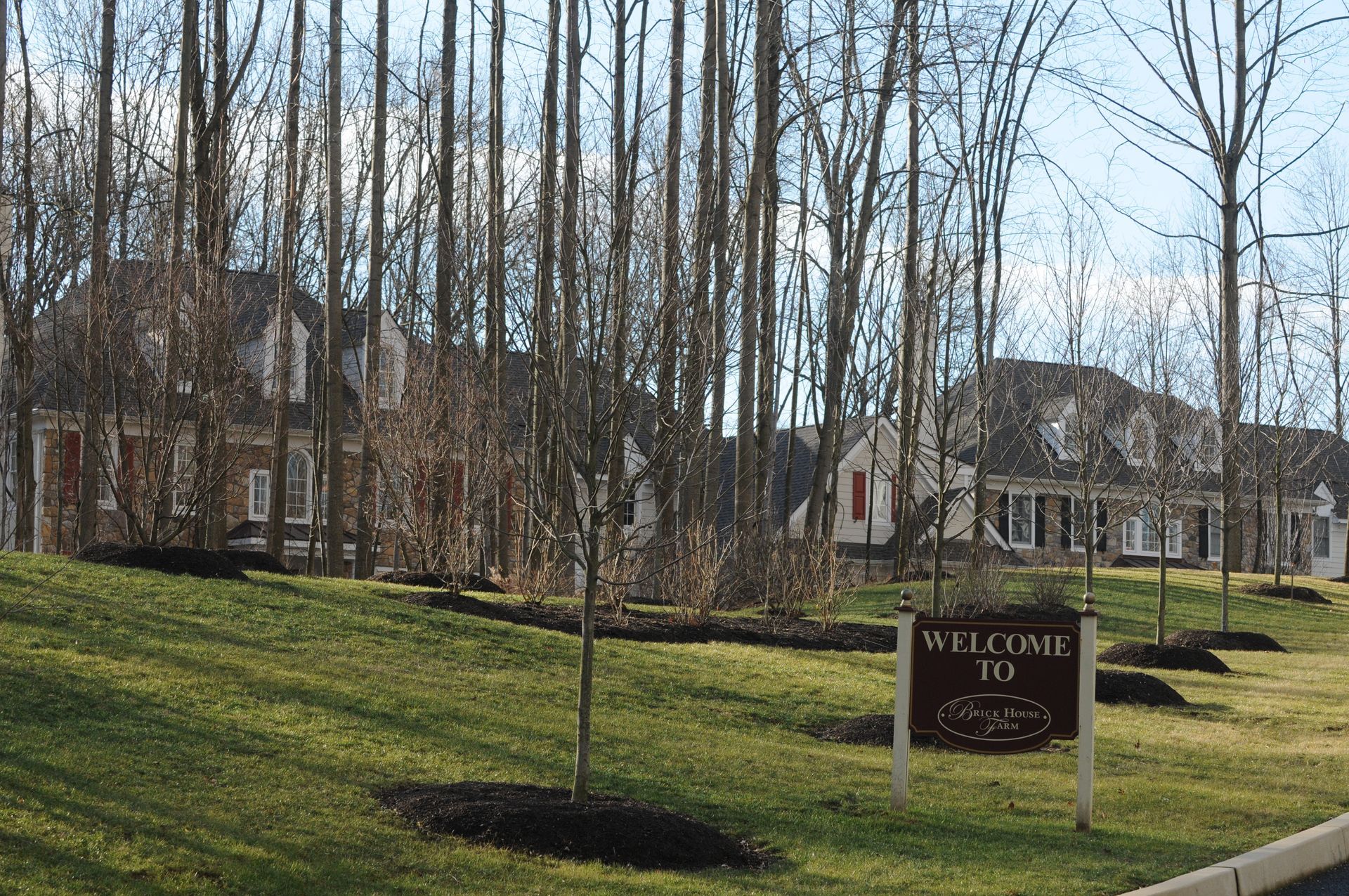 A welcome to sign is in the middle of a lush green field