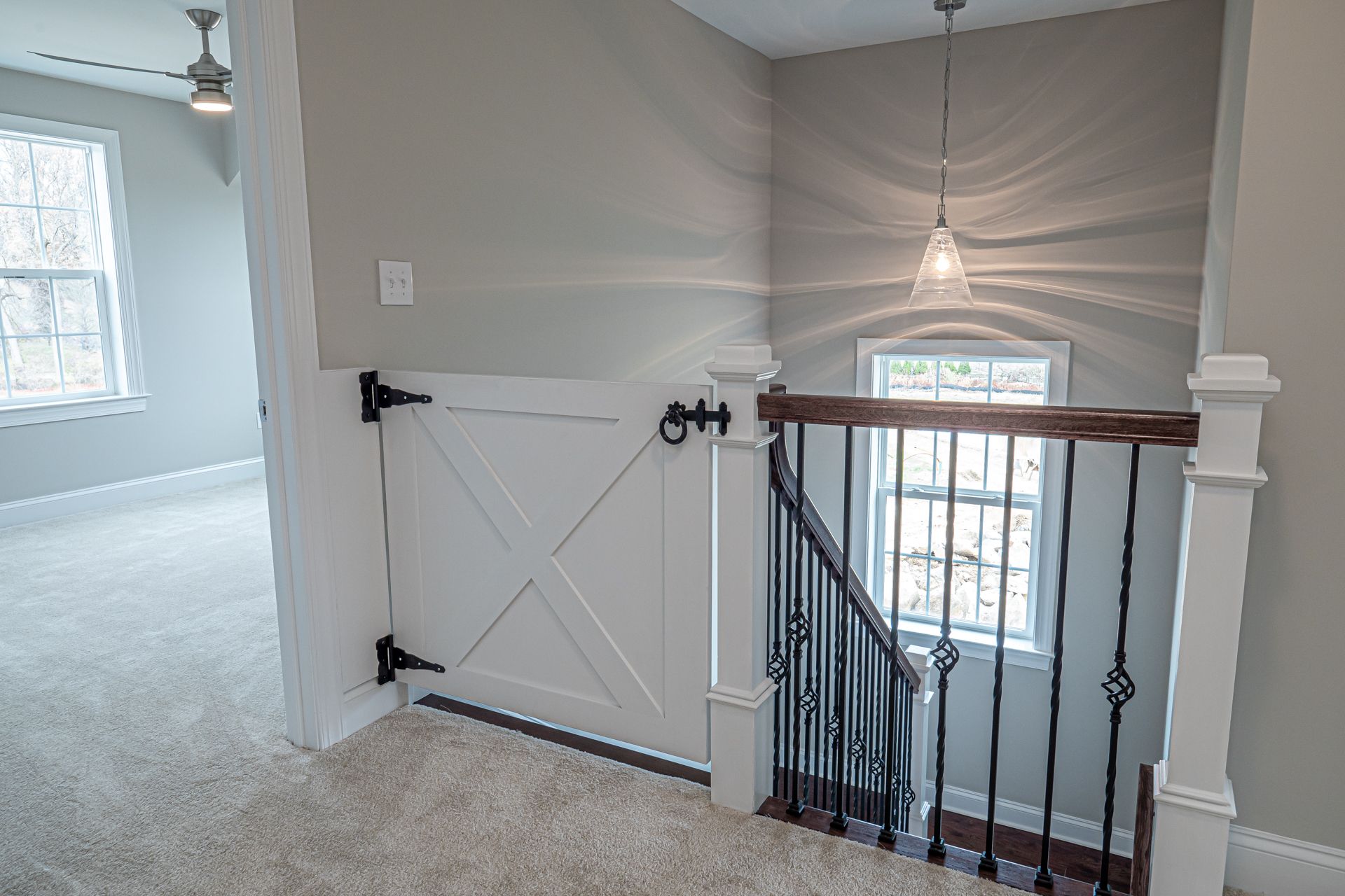 A staircase with a wooden railing and a barn door.