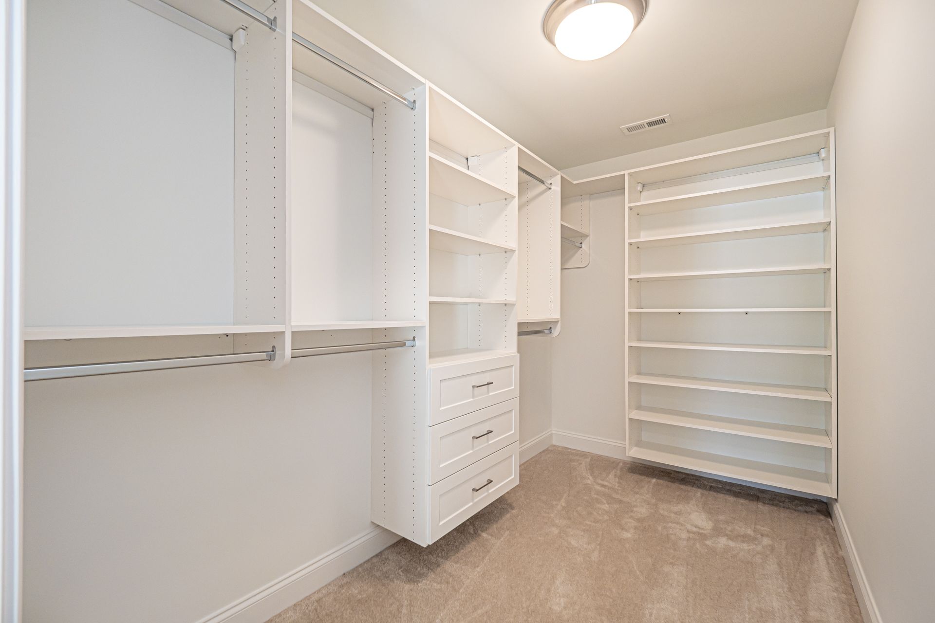 A walk in closet with lots of shelves and drawers.