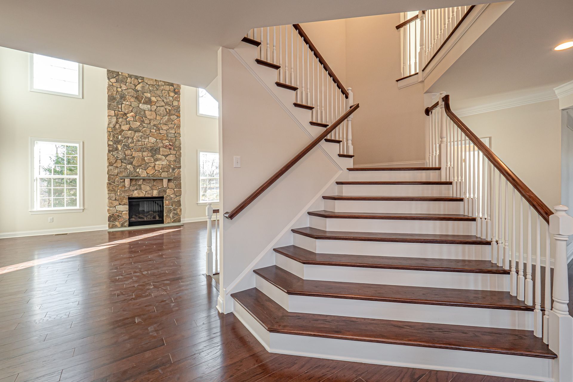 An empty house with a staircase and a fireplace