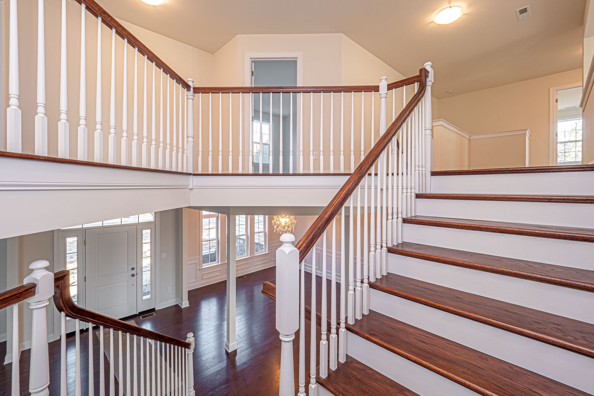 A staircase in a house with white railings and wooden steps