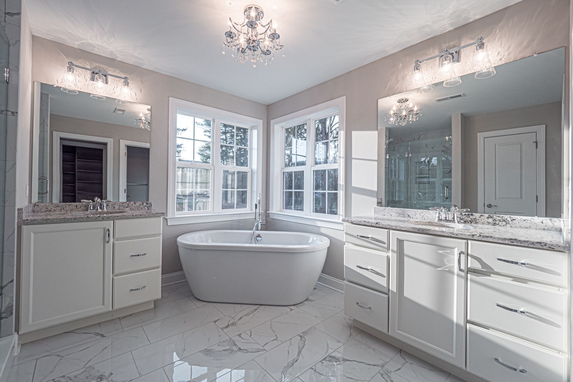 A bathroom with two sinks , a tub , and two mirrors.