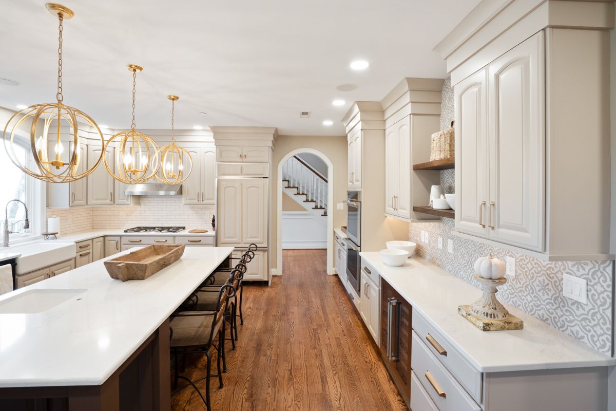 A kitchen with white cabinets and a large island in the middle.