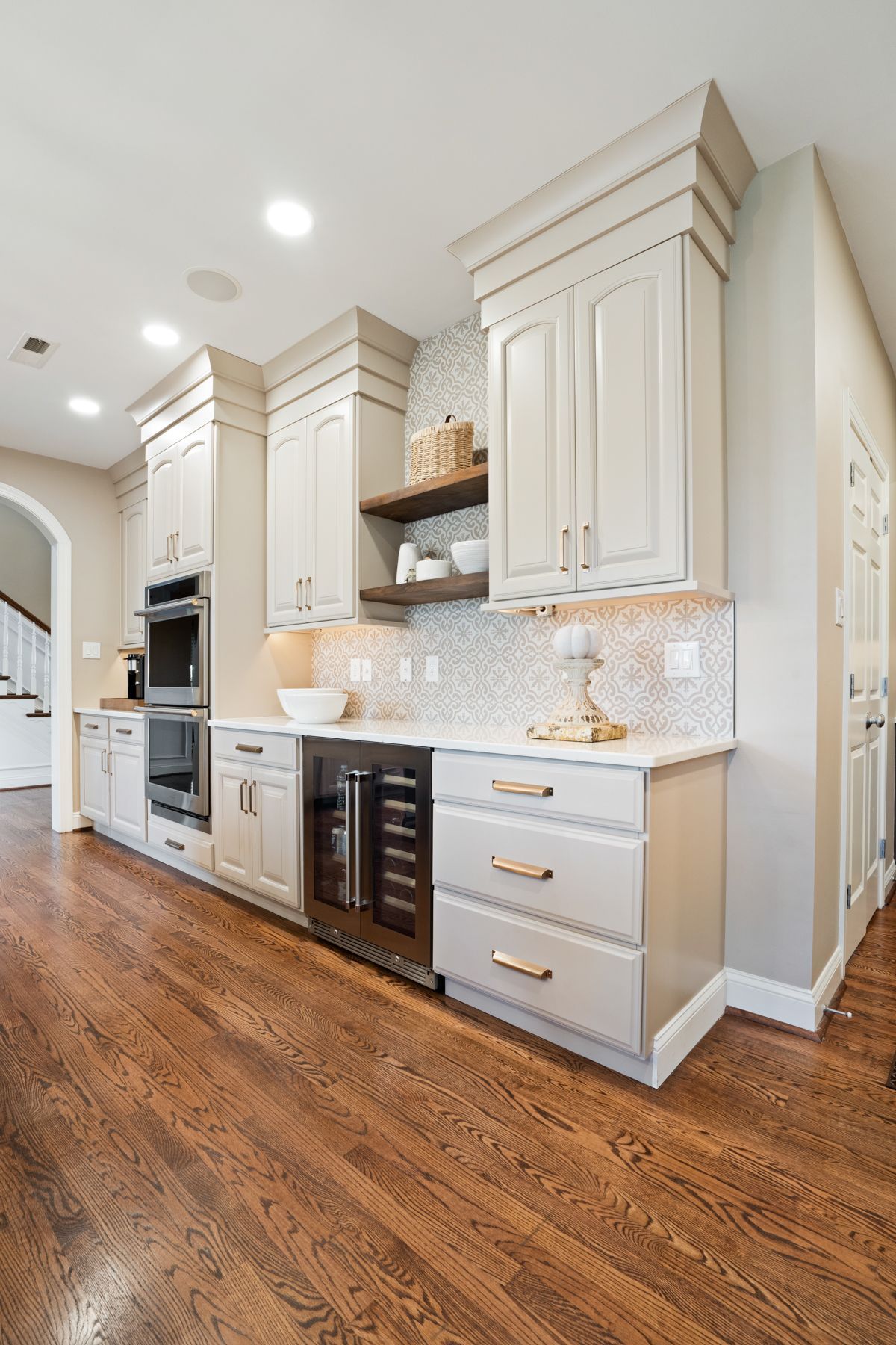 A kitchen with white cabinets , stainless steel appliances , and hardwood floors.