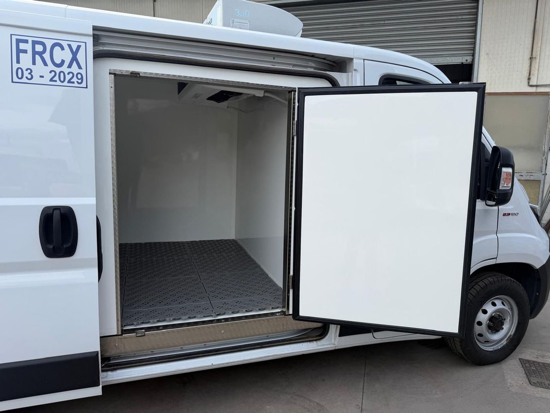 Furgone bianco per le consegne con sportello laterale aperto e vano di carico vuoto.