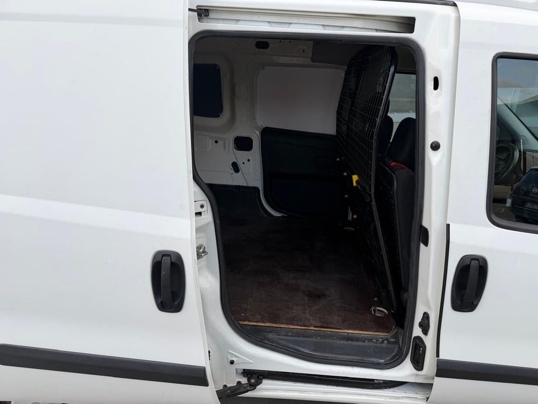 Sportello scorrevole aperto su un furgone bianco, che mostra il vano di carico vuoto all'interno.