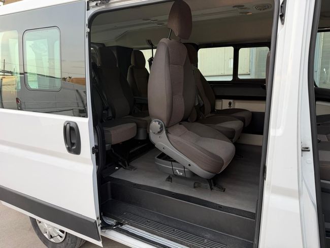 Furgone bianco con portellone scorrevole aperto, che lascia intravedere i sedili grigi dell'auto e un interno spazioso.