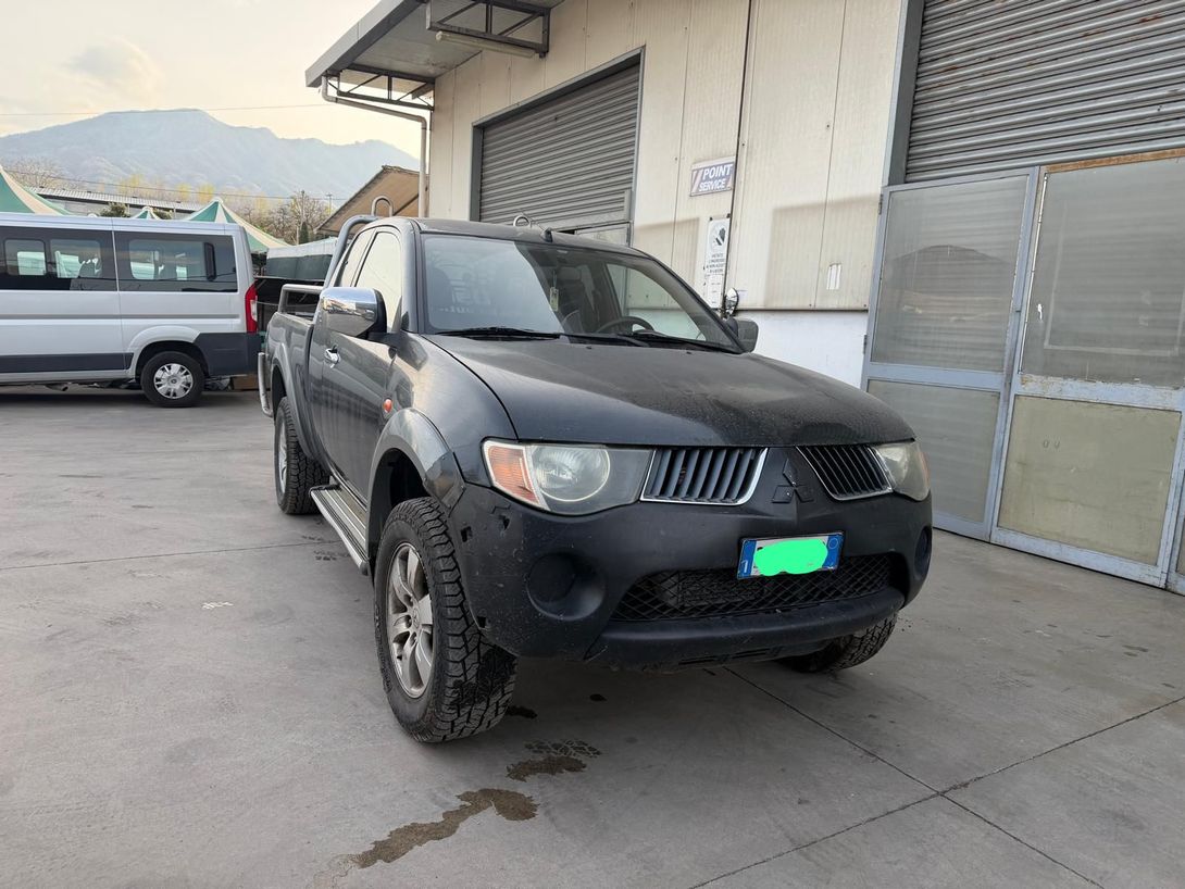 Un pick-up nero parcheggiato accanto alla banchina di carico di un magazzino, con le montagne sullo sfondo.