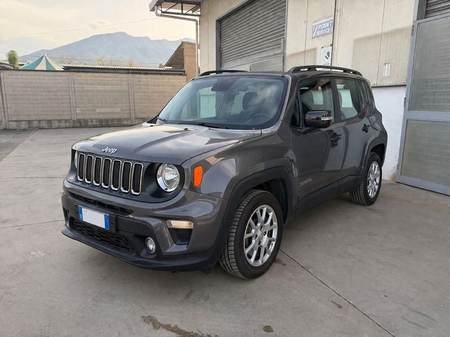 Jeep Renegade grigia parcheggiata in un'area industriale accanto a un edificio e a delle porte da garage.