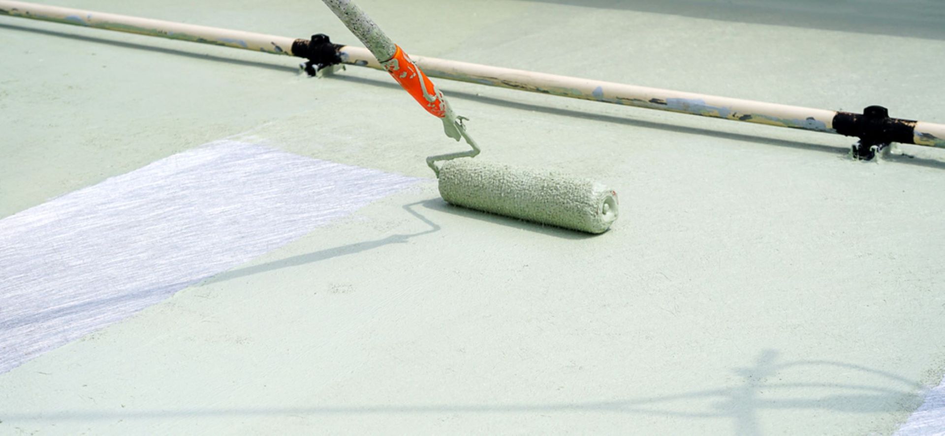 A Person is Painting a Roof With a Roller — A&J Painting In Woden, NT