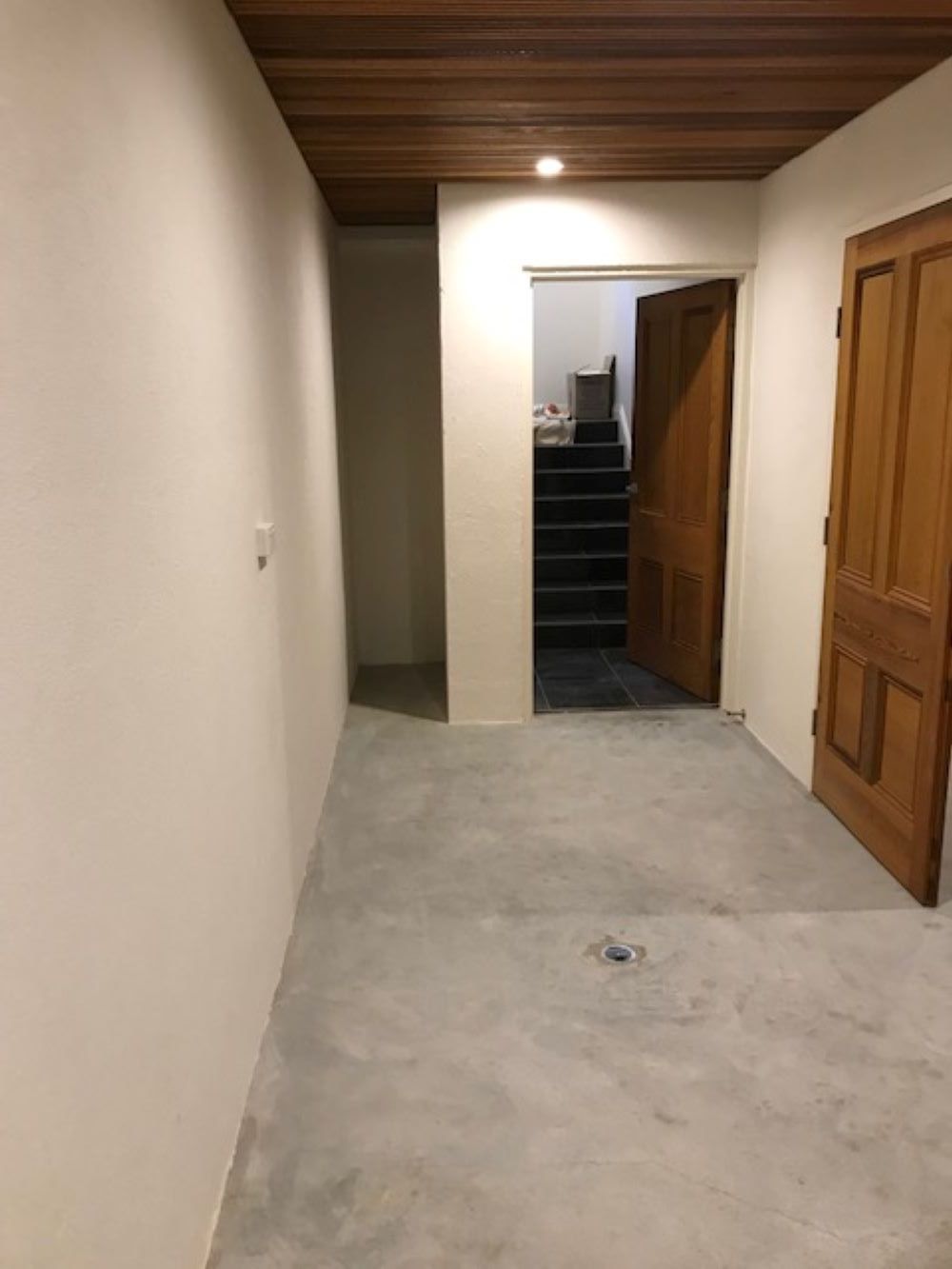 An Empty Hallway With a Wooden Door and Stairs in the Background — A&J Painting In Gungahlin, NT