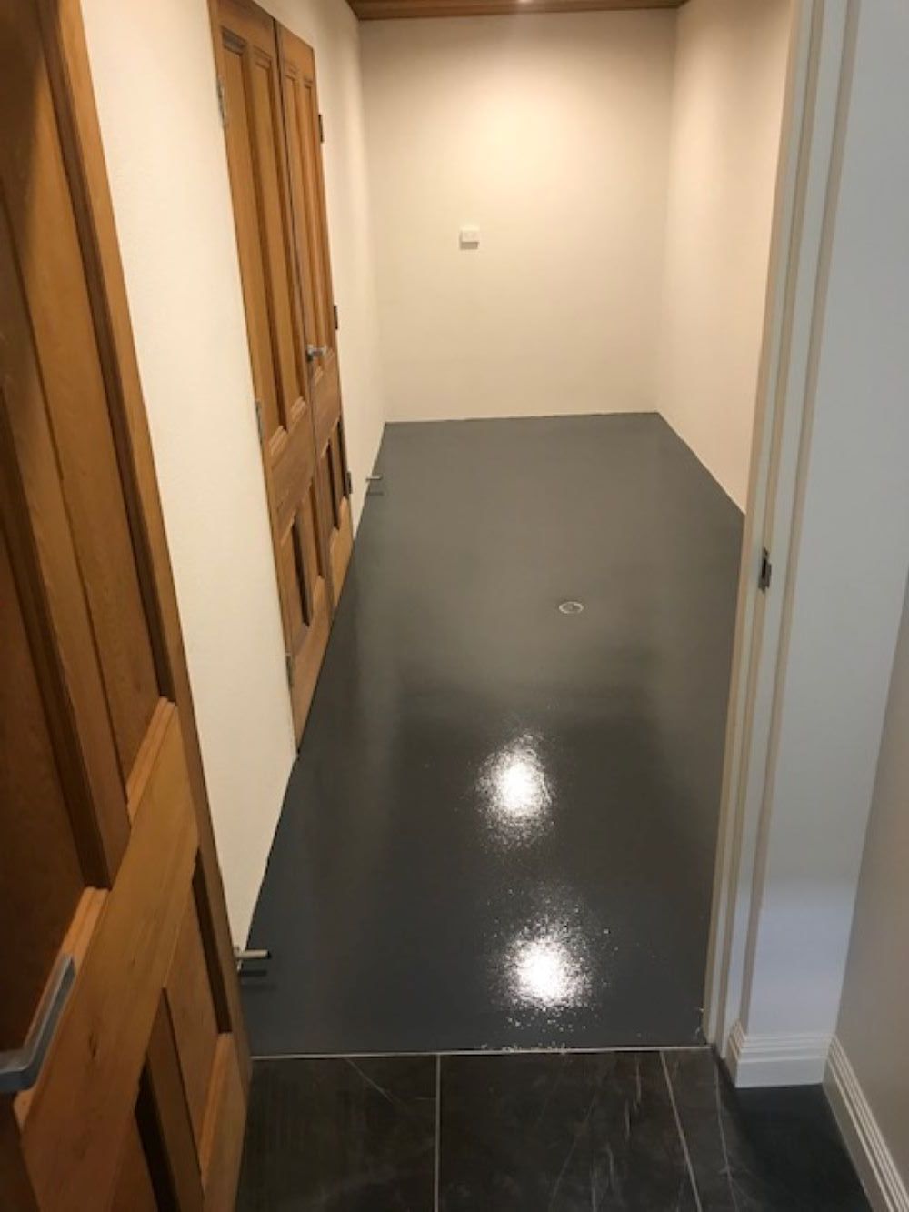 A Hallway With a Gray Floor and Wooden Doors Leading to a Room — A&J Painting In Gungahlin, NT