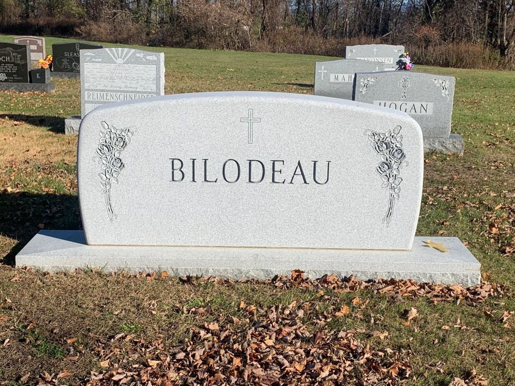 A gravestone in a cemetery with the name bilodeau on it.