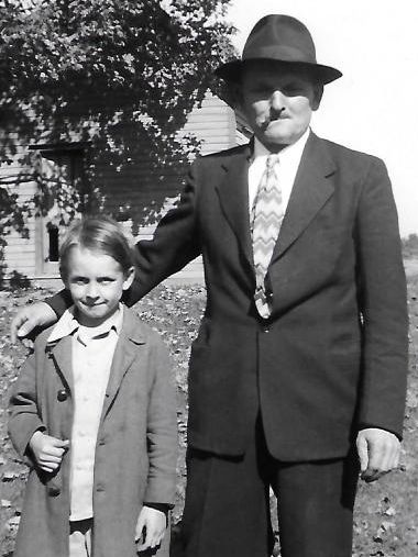 A man in a suit and tie stands next to a little girl