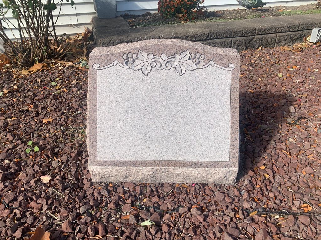 A gravestone is sitting on top of a pile of gravel.