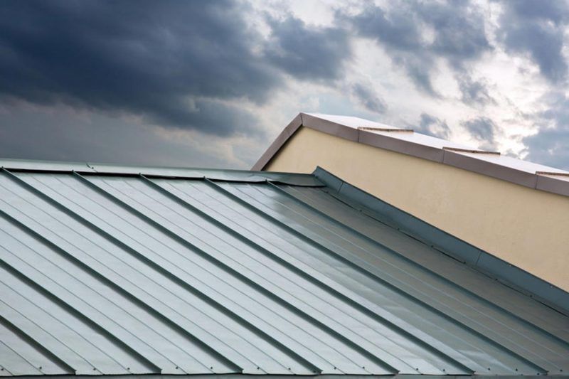 A metal roof with a cloudy sky in the background