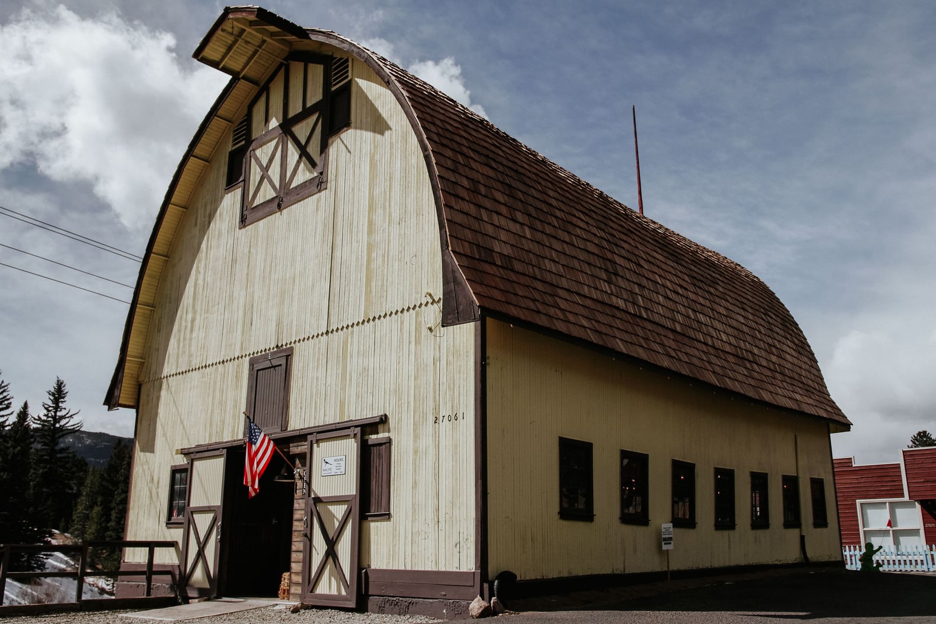 A large barn with a red white and blue flag on the door