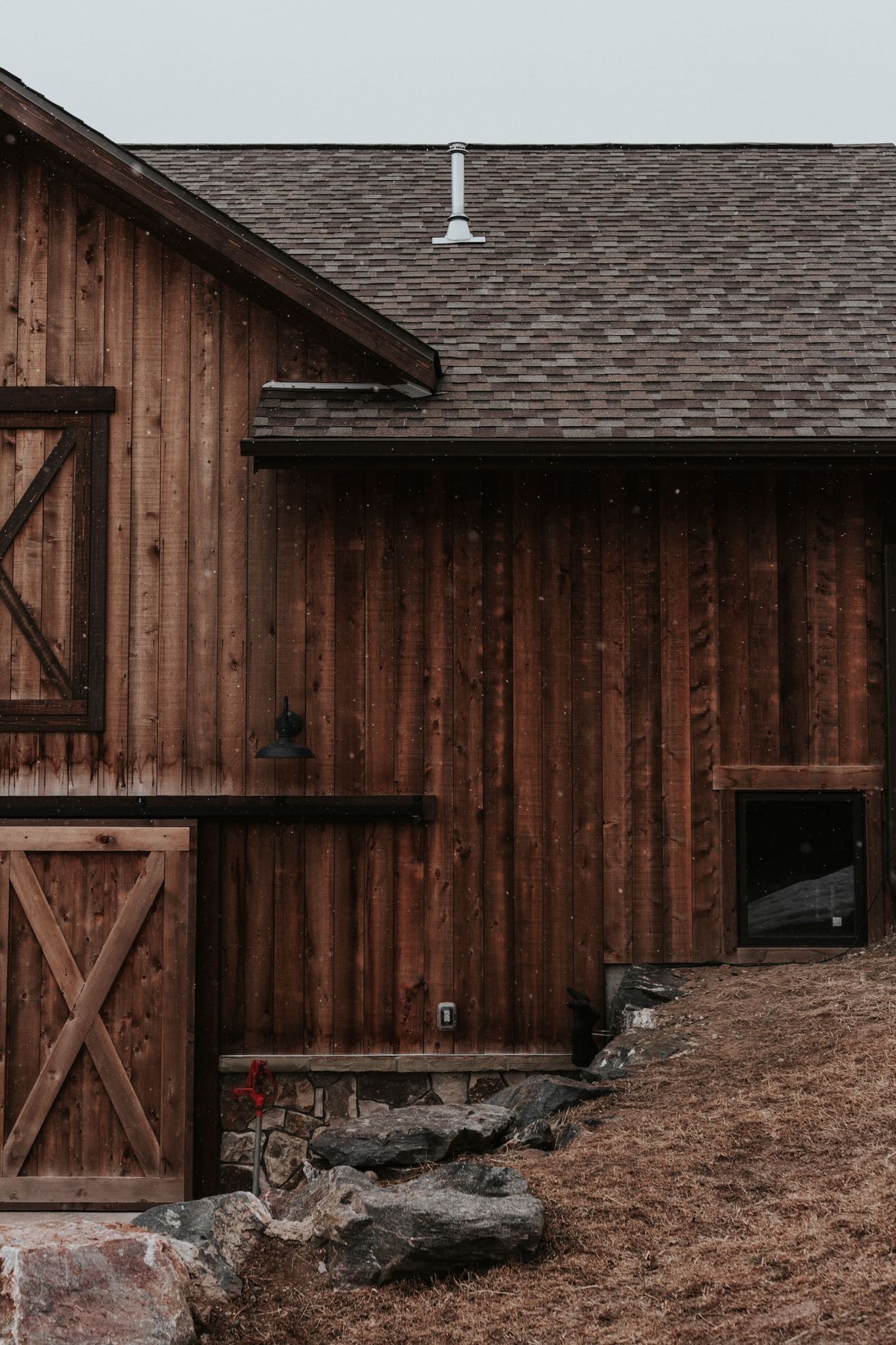 A wooden barn with a roof and a door.