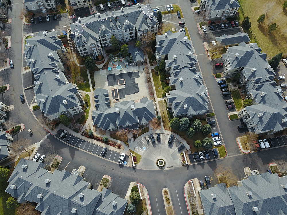 An aerial view of a residential area with lots of buildings and parking lots.