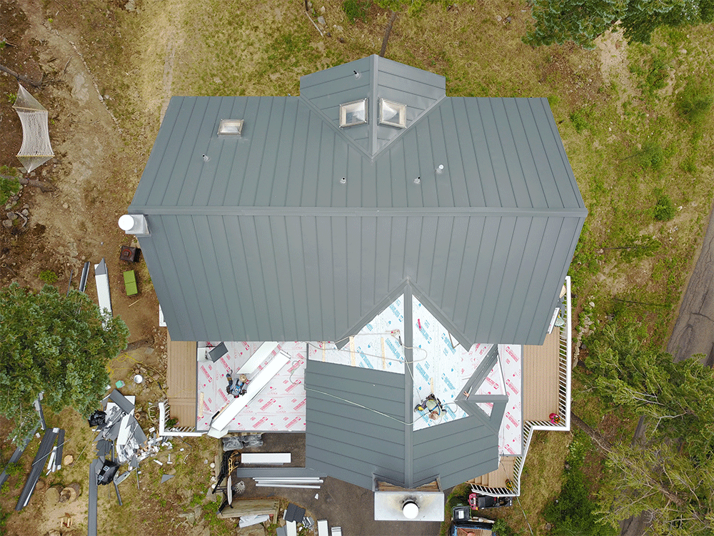 An aerial view of a house under construction with a gray roof.