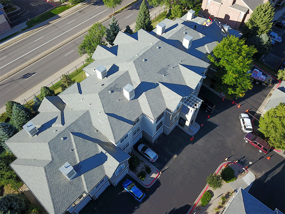 An aerial view of a building with a lot of cars parked in front of it.