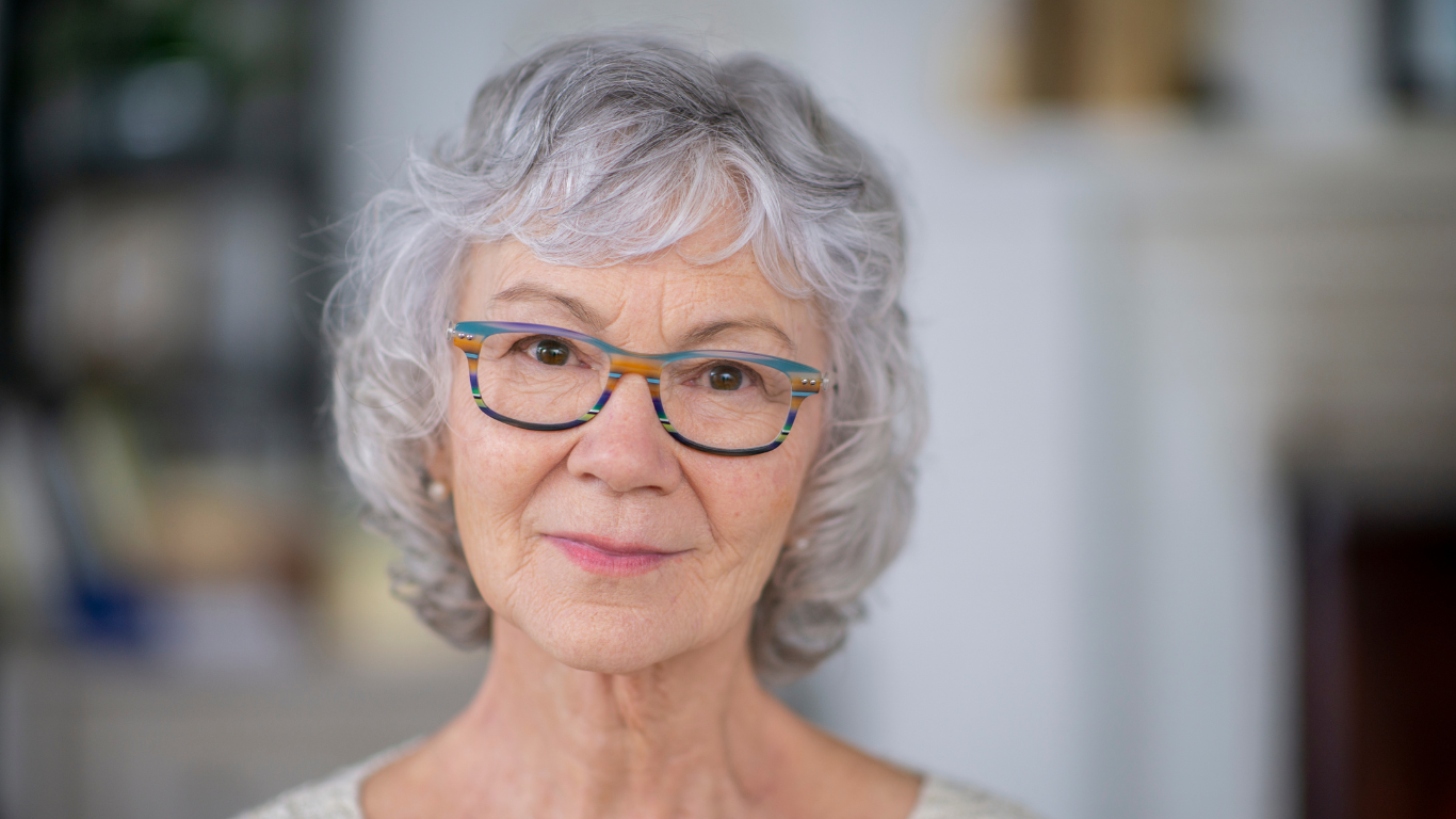 A close up of an older woman wearing glasses.