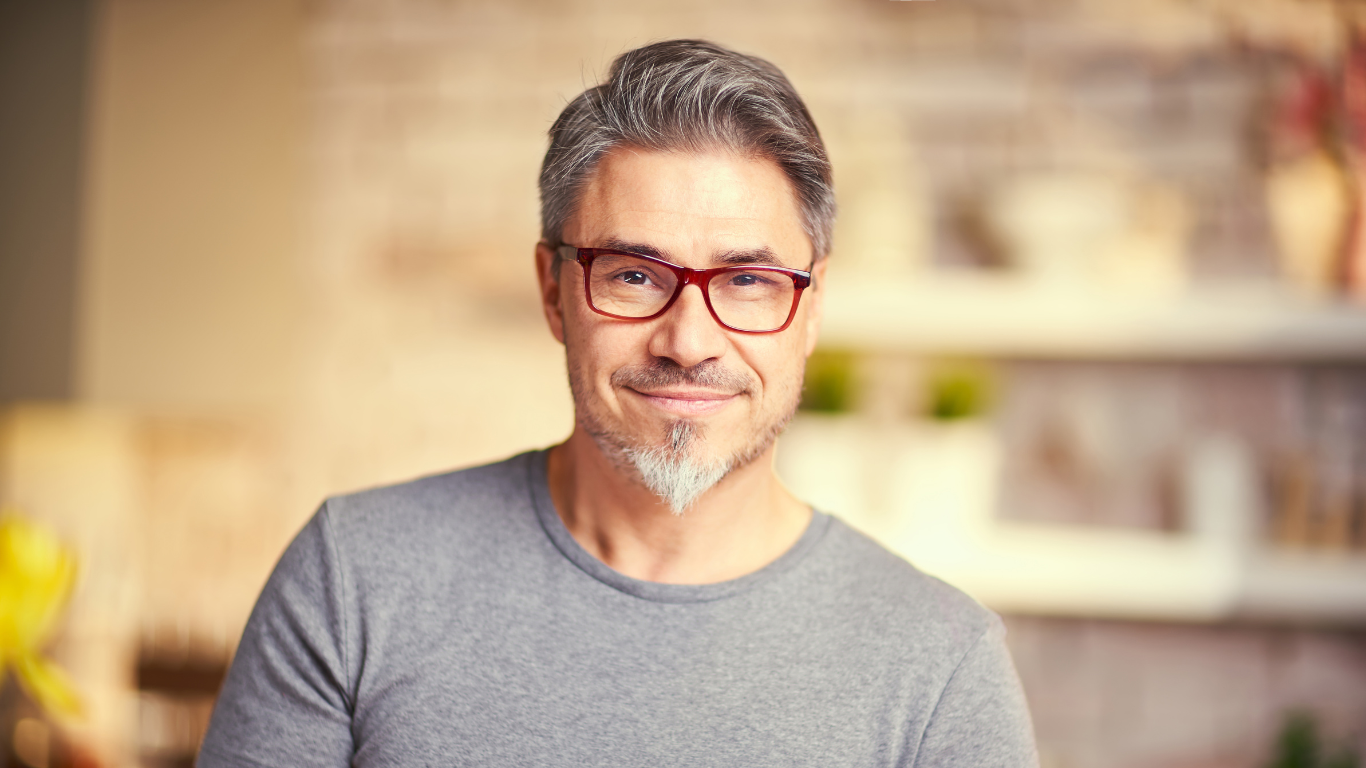 A man with glasses and a beard is smiling for the camera.